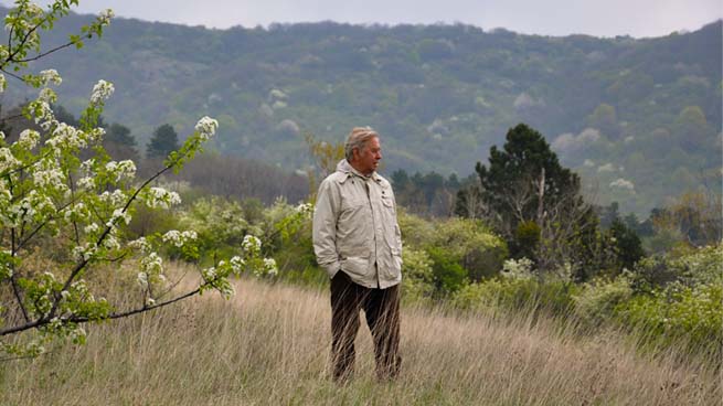 Dr Hans Bibelriether stands on a windy autumn meadow