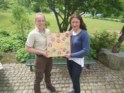 Kristin Biebl (links) übergibt die Ansteckbuttons der Junior Ranger an Marina Waldhauser von der Touristinfo Spiegelau. Foto: Ferienregion Nationalpark Bayerischer Wald