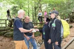 Lukas Laux (v.l.) und Werner Kaatz überreichen an die Waldführerinnen Marianne Melch und Jutta Pongratz das Begleitheft für den Naturerlebnispfad – ein ganz besonderes Erlebnis im Waldspielgelände. (Foto: Annette Nigl/Nationalpark Bayerischer Wald).