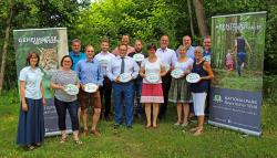 Nationalparkleiter Franz Leibl (3. von links), Nationalparkmitarbeiterin Katrin Wachter (links) und Jochen Stieglmeier (3. von rechts), Vorsitzender des Partnervereins, freuen sich über elf neue Betriebe in die Familie der Nationalpark-Partner auf. (Foto: Elke Ohland/Nationalpark Bayerischer Wald)