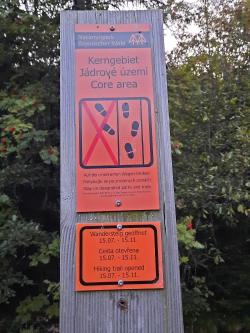 Diese orangenen Schilder weisen im Gelände auf die geltenden Betretungsregeln im Nationalpark-Kerngebiet hin. Wo dieser Hinweis hängt, ist der Zutritt von 16. November bis 14. Juli nicht erlaubt. (Foto: Annette Nigl/Nationalpark Bayerischer Wald)