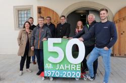 Die Nationalparkmitarbeiter Annemarie Schmeller (l.), Andreas Stumpp (3.v.l.), Johannes Schmid (v.r.) und Hans-Georg Simmet übergaben zusammen mit Leiter Dr. Franz Leibl (4.v.l.) den Jubiläums-Würfel an Direktor Dr. Richard Loibl (4.v.r.) und seine Mitarbeiter Raphaela Holzer (3.v.r) und Dr. Timo Nüßlein (2.v.l.). (Foto: Annette Nigl/Nationalpark Bayerischer Wald)