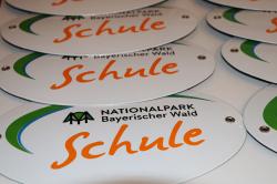 Ein Türschild aus Emaille mit dem Logo der Nationalpark-Schule erhielten die Vertreter der Schulen als Geschenk.