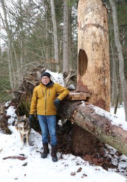 Werner Kaatz mit seiner Hündin Caja an einem seiner Lieblingsplätze im Waldspielgelände in Spiegelau, der Spechthöhle. (Foto: Julia Reihofer/Nationalpark Bayerischer Wald)