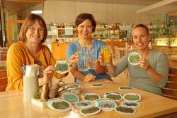 Testeten in der Gastronomie vom Haus zur Wildnis schon mal den Einsatz der neuen Obacht-Bierdeckel: Elke Ohland (von links) vom Nationalpark sowie die beiden Ideengeberinnen Katrin Roiger und Theresa Hinkofer. (Foto: Nationalpark Bayerischer Wald)