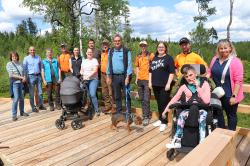 Der Bohlensteg durch das Finsterauer Filz ist auch für gehandicapte Personen und Familien bestens geeignet. Davon konnten sich die Mitarbeiter des Nationalparks rund um Dr. Franz Leibl (Mitte), Bürgermeister Ernst Kandlbinder (2.v.), Familienbeauftragte Verena Gostic (4.v.r.) sowie Marlene im Rollstuhl und Linda im Kinderwagen überzeugen. (Foto: Nationalpark Bayerischer Wald)