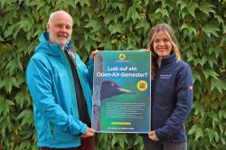 Nationalpark-Umweltbildungsreferent Lukas Laux und Hanna Oßing, die gerade noch ihr Commerzbank-Umweltpraktikum im Bayerischen Wald ableistet, mit dem Plakat für die gerade angelaufene Bewerbungsphase für die begehrten Praktikumsplätze im Jahr 2024. (Foto: Nationalpark Bayerischer Wald)