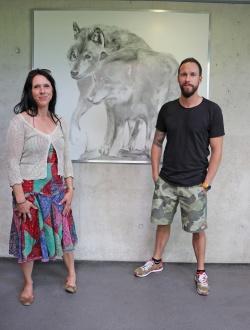 Die Künstler Britta Wahlers und Robert Marc Lehmann posieren im Haus zur Wildnis vor einer der großformatigen Tierzeichnungen. (Foto: Gregor Wolf/Nationalpark Bayerischer Wald)