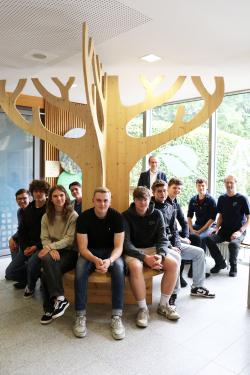 Dank der Glasfront mit Schul- und Nationalparklogo ist der Baum samt Sitzbank in der Nationalpark-Ecke nicht nur drinnen ein Hingucker, sondern auch von draußen. Stolz darauf sind die Schüler des letztjährigen P-Seminars sowie Studiendirektor Michael Behringer (v.r.), Jan Kiesling vom Nationalpark und stellvertretender Schulleiter Andreas Schewiola.