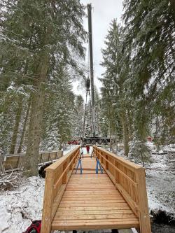 Noch am Haken: Die Brücke über die Schwarzach wurde in einem Stück eingehoben. (Foto: Johannes Dick / Nationalpark Bayerischer Wald)