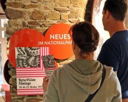 Im Hans-Eisenmann-Haus informieren sich bereits die ersten Besucher über die NaturVision Filmtage Bayerischer Wald 2017. (Foto: Gregor Wolf/Nationalpark Bayerischer Wald)