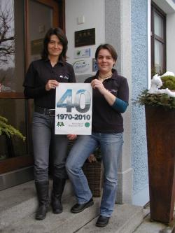 Sandra de Graaf (links) und Britta Baums zeigen mit einem Plakat, dass der 40. Geburtstag des Nationalparks Bayerischer Wald heuer im Mittelpunkt der Nationalpark-Partner-Initiativen stehen wird.