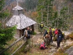 Rast an der Rachelkapelle. 
Der Leiter der Nationalparkwacht Josef Erhard (links) erzählt seinen tschechischen Kollegen von den Sagen um diese hoch über dem Rachelsee erbaute Gedenkstätte