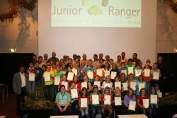 Stolz präsentieren die frischgebackenen Junior Ranger ihre Zertifikate im Filmsaal des Hans-Eisenmann-Hauses. Mit dabei ihre „Ausbilder“, die Seniorranger und MdB A. Muthmann als 1. Vorsitzender des Junior Ranger-Vereins e.V. (links), der Leiter der Nationalparkwacht J. Erhard (rechts), Sparkassendirektor T. Domani (hintere Reihe 3. v.l.) und Nationalparkleiter Dr. F. Leibl (hintere Reihe rechts)