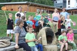 Kinder der Montessori Schule Freyung (Nationalpark-Schule seit 2011) präsentieren stolz der Leiterin des Jugendwaldheims Rita Gaidies (links vorne)  den selbstgebauten Lehmofen. (Foto:NPV)